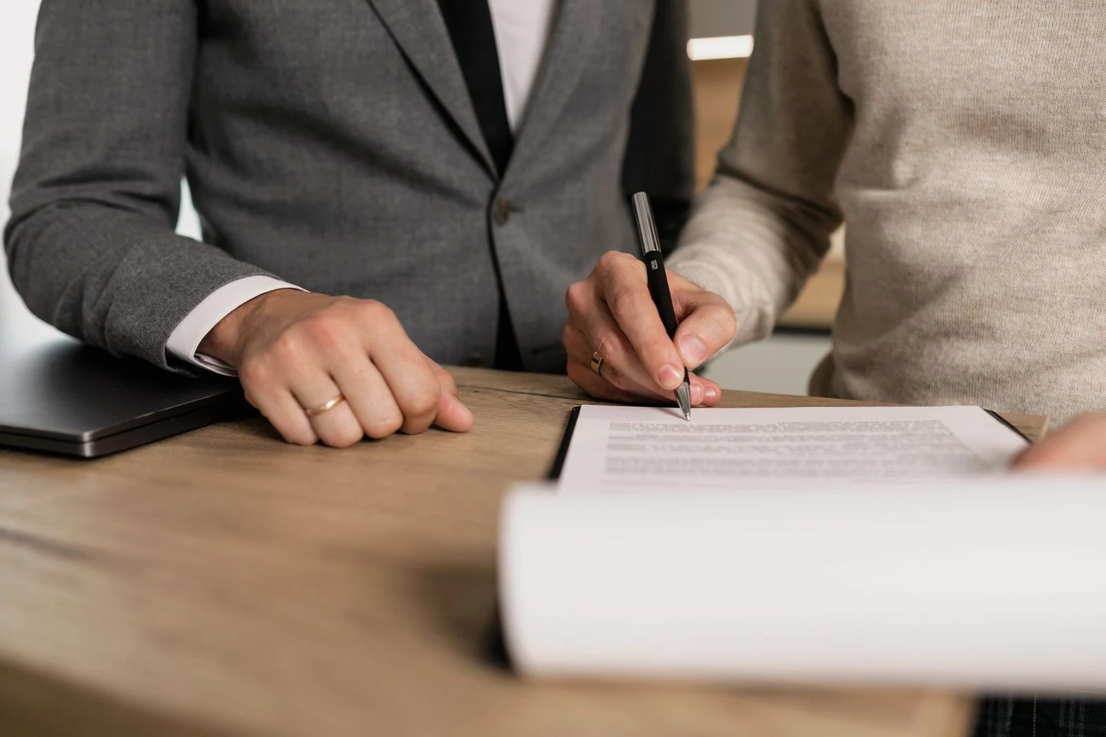 Profissional assinando petição em escritório, etapa de oposição de marca no INPI