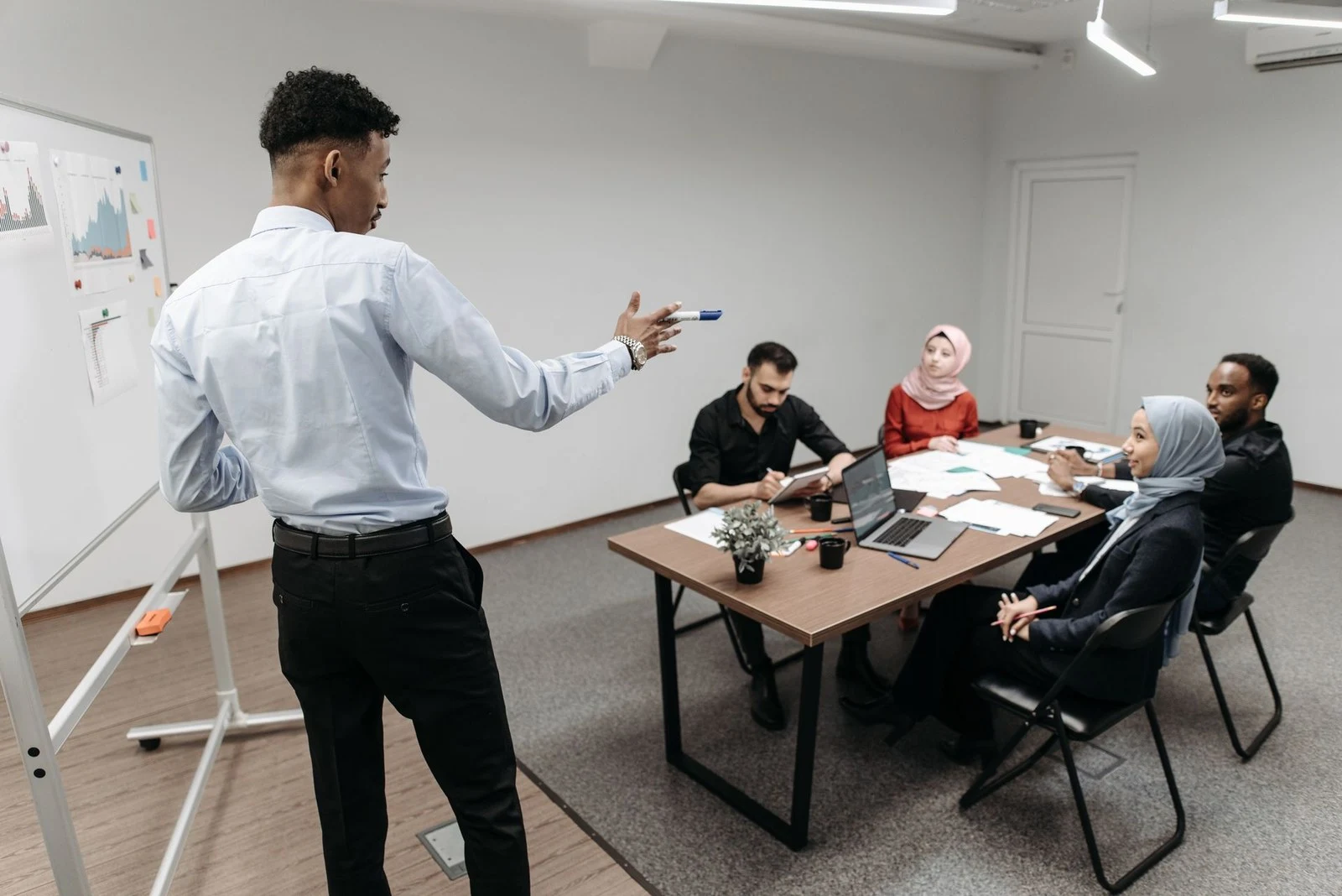 Equipe reunida em torno de uma mesa com documentos e notebooks, discutindo a gestão da carteira de propriedade intelectual